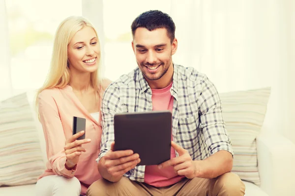 Casal feliz com tablet pc e cartão de crédito — Fotografia de Stock