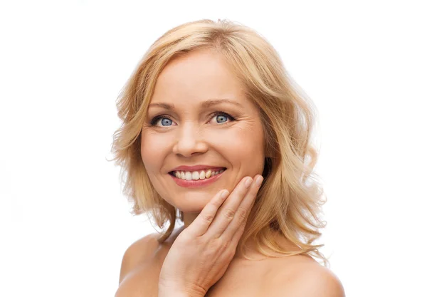 Smiling woman with bare shoulders touching face — Stock Photo, Image
