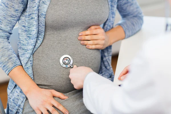 Medico con stetoscopio e pancia di donna incinta — Foto Stock