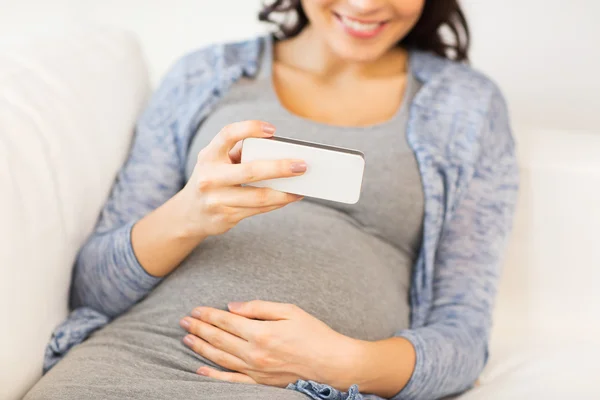 Gros plan de la femme enceinte avec smartphone à la maison — Photo