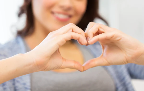 Gros plan de femme heureuse montrant le cœur avec les mains — Photo