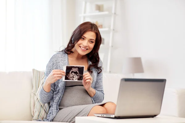 Mujer embarazada feliz con imagen de ultrasonido en casa —  Fotos de Stock