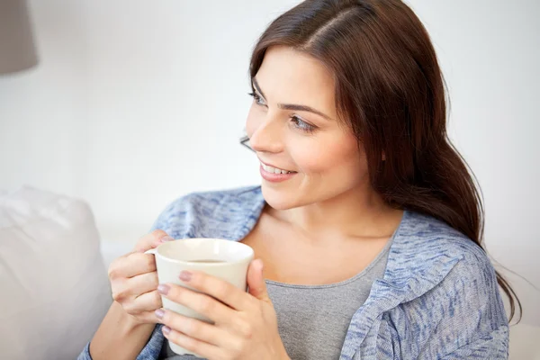 Happy woman with cup of tea or coffee at home — Stock Photo, Image