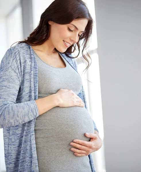 Gelukkig zwangere vrouw met grote buik thuis — Stockfoto