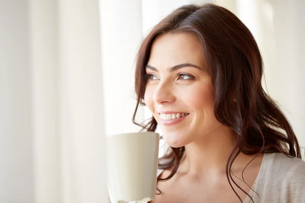 Femme heureuse avec tasse de thé ou de café à la maison — Photo