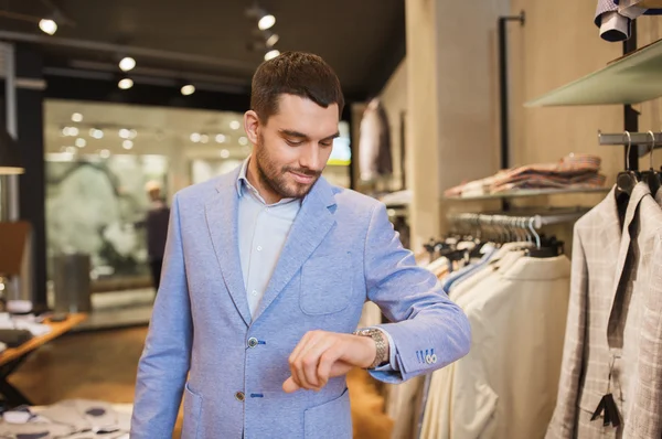 Hombre feliz en chaqueta con reloj en la tienda de ropa — Foto de Stock