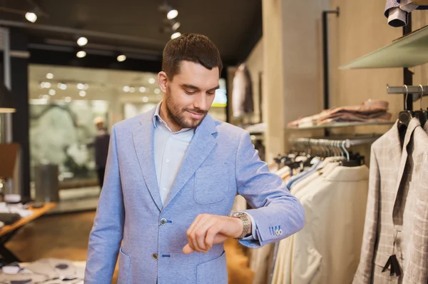 Gelukkig man in jas met watch op kleding opslaan — Stockfoto