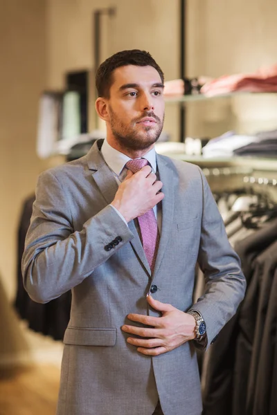 Młody człowiek próbuje garnitur w w sklepie odzieżowym — Zdjęcie stockowe