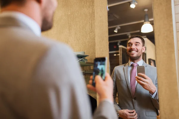 Muž v obleku s zrcadlo selfie v obchodě s oděvy — Stock fotografie