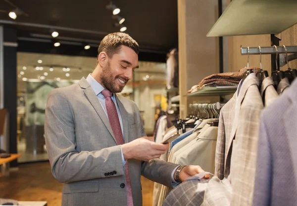 Mann im Anzug mit Smartphone im Bekleidungsgeschäft — Stockfoto