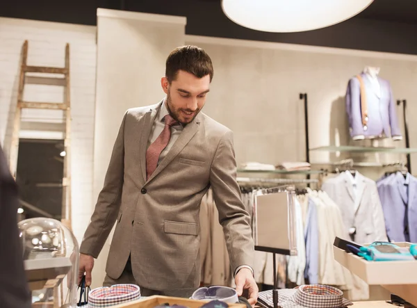 Glücklicher junger Mann wählt Hemd im Bekleidungsgeschäft — Stockfoto