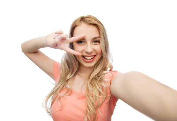 Femme souriante prenant selfie et montrant signe de paix — Photo