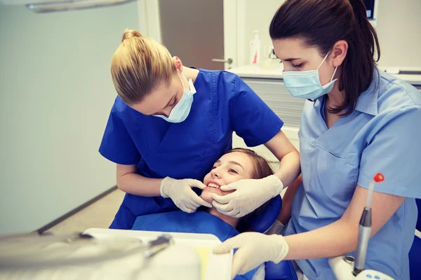 Mutlu kadın dişçi klinikte hasta kızla — Stok fotoğraf