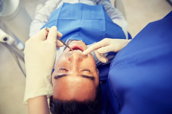 Närbild på tandläkare kontrollera manliga patientens tänder — Stockfoto