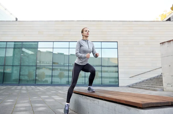 Woman making step exercise on city street bench — Stock Photo, Image