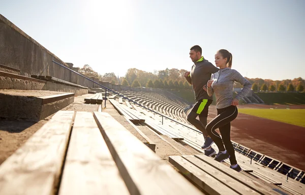 Feliz pareja corriendo arriba en el estadio — Foto de Stock