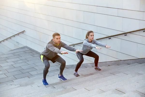 Par gör knäböj på staden gatan trappor — Stockfoto