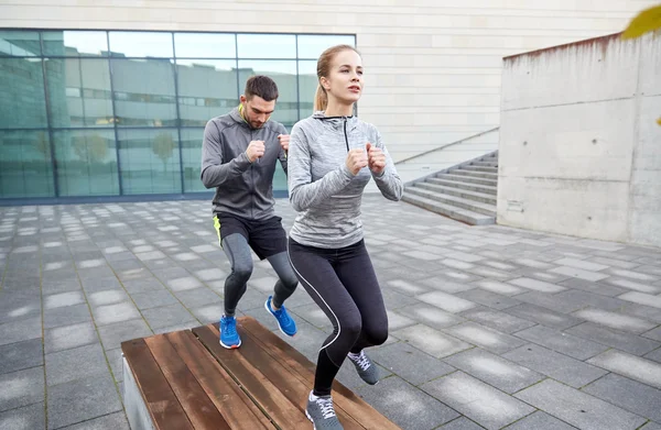 Paar macht Schrittübung auf städtischer Straßenbank — Stockfoto