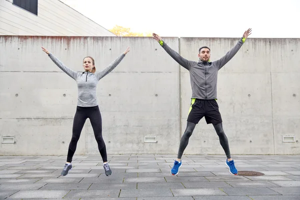 Feliz hombre y mujer saltando al aire libre — Foto de Stock