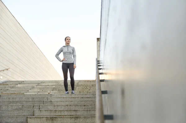 Mujer deportiva de pie en las escaleras de la ciudad — Foto de Stock