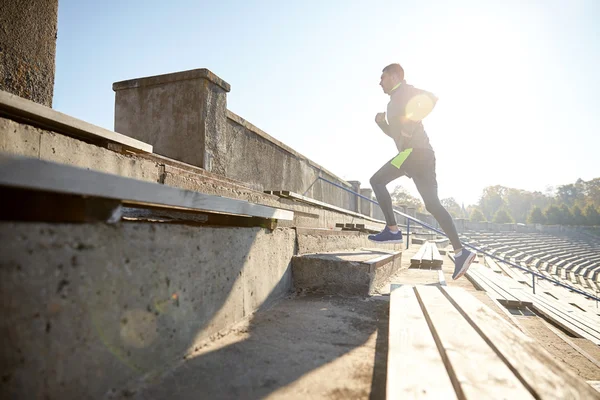 Heureux jeune homme courant à l'étage sur le stade — Photo