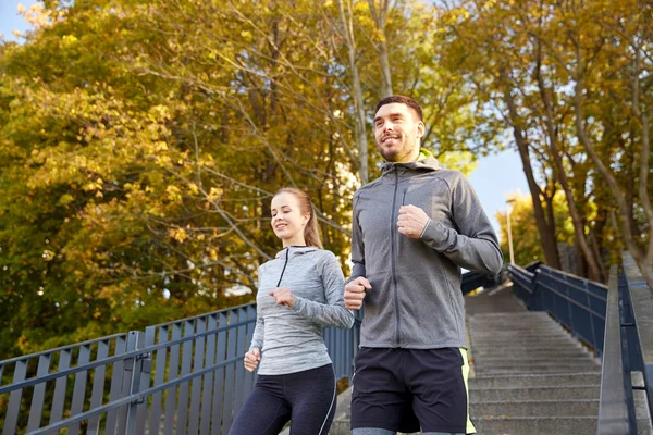 Heureux couple courir en bas dans la ville — Photo