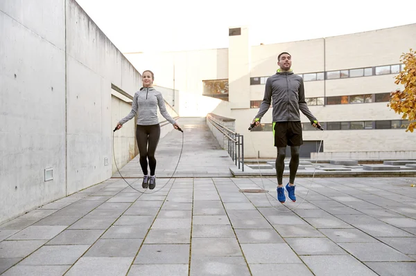 Hombre y mujer haciendo ejercicio con cuerda de salto al aire libre — Foto de Stock