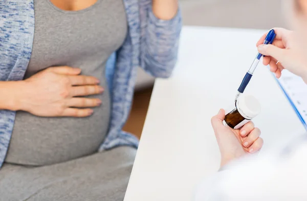 Close up of doctor showing pills to pregnant woman — Stock Photo, Image