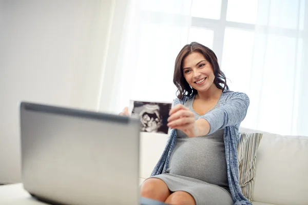 Gelukkig zwangere vrouw met echografie afbeelding thuis — Stockfoto