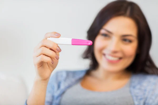 Gros plan de la femme heureuse avec test de grossesse à la maison Photos De Stock Libres De Droits