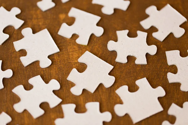 Close up of puzzle pieces on wooden surface — Stock Photo, Image