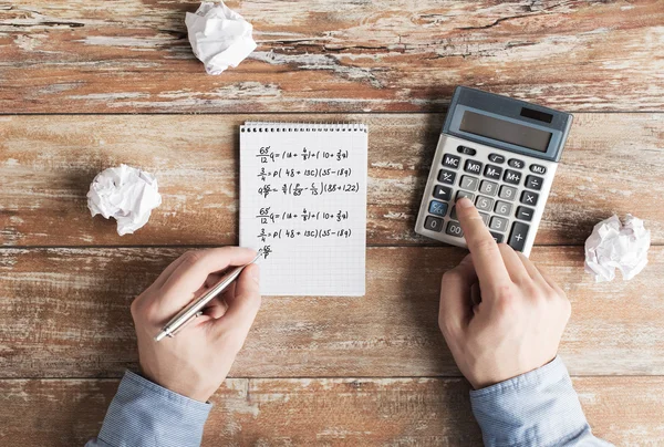 Close up of hands with calculator solving task — Stock Photo, Image