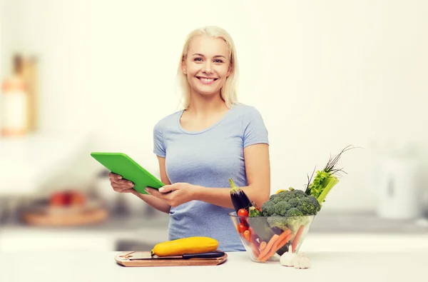 Lachende vrouw met tablet pc koken groenten — Stockfoto