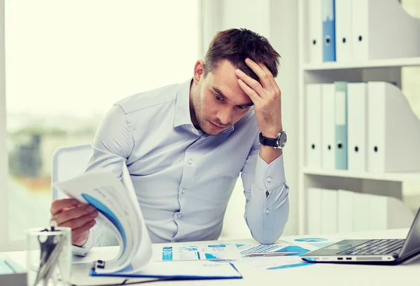 Stressad affärsman med papper på kontor — Stockfoto