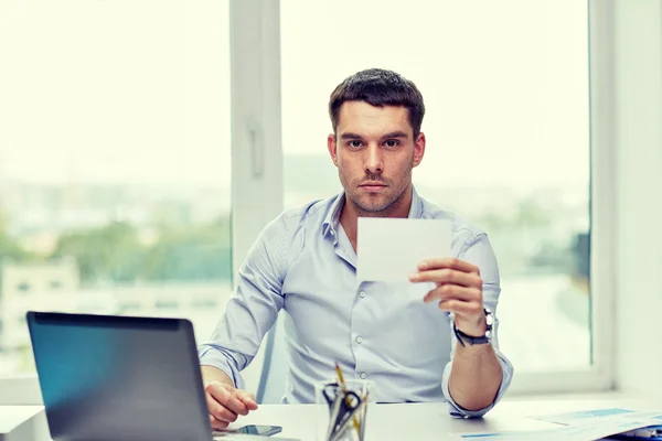 Hombre de negocios mostrando la tarjeta de papel en blanco en la oficina — Foto de Stock