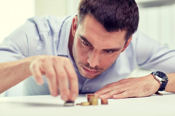 Hombre de negocios con monedas en la oficina — Foto de Stock