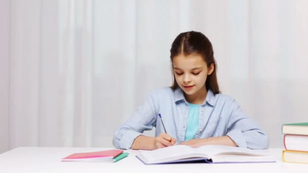 Chica de la escuela feliz con libros y bloc de notas en casa — Vídeo de stock