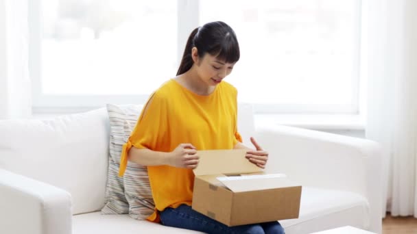 Gelukkig aziatische jong vrouw met pakket doos thuis — Stockvideo