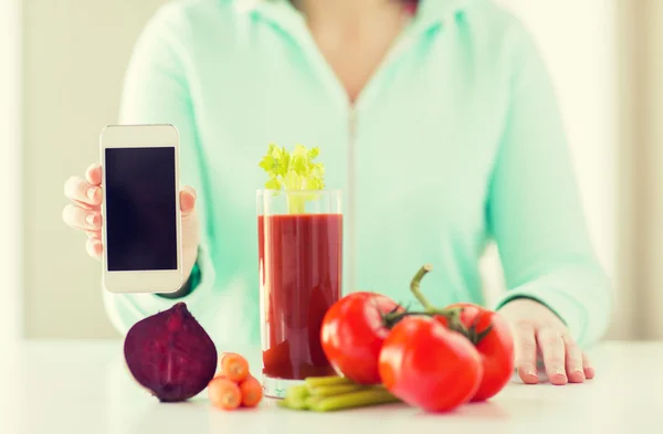 Närbild på kvinna med smartphone och grönsaker — Stockfoto