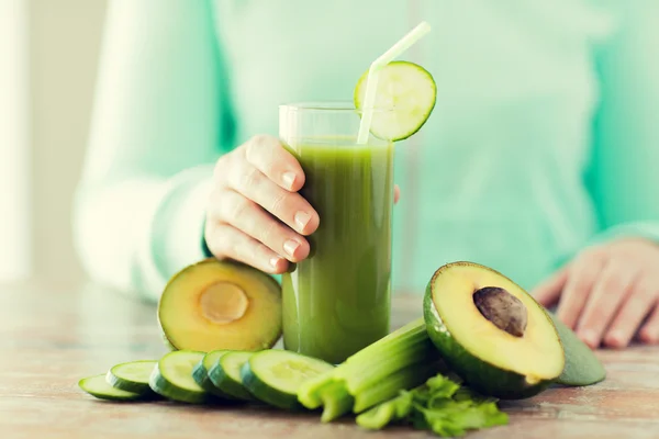 Close up de mãos de mulher com suco e legumes — Fotografia de Stock