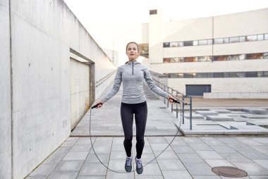 woman exercising with jump-rope outdoors clipart