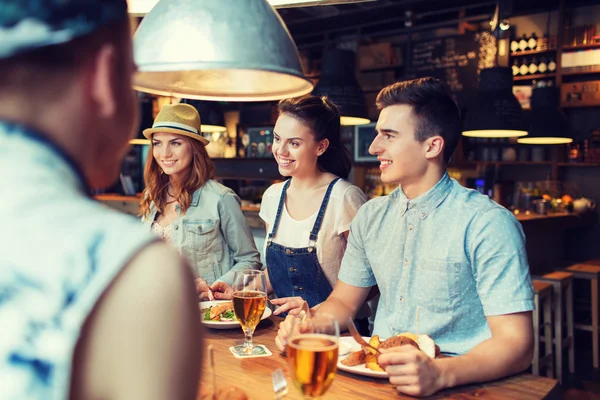 Amis heureux manger et boire au bar ou pub — Photo