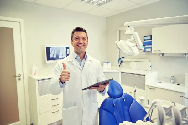 หมอฟันที่มีความสุข แสดงนิ้วโป้งขึ้นกับแท็บเล็ตพีซี — ภาพถ่ายสต็อก