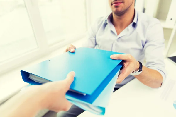Close up of businessman taking folders from hand — Stock Photo, Image