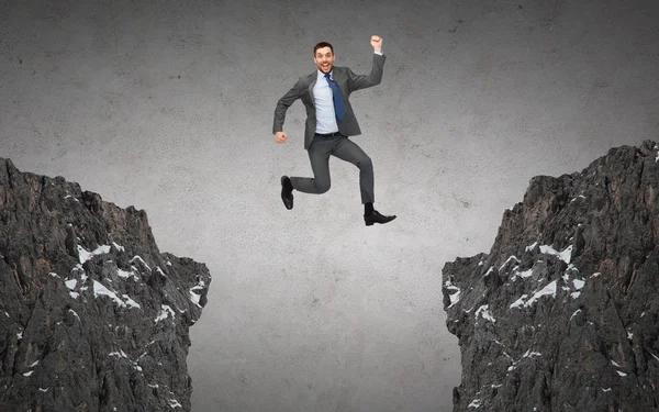 Feliz sonriente hombre de negocios saltando entre rocas — Foto de Stock