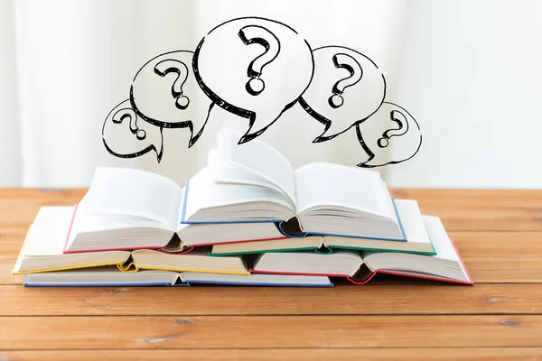 Close up of books on table and question marks — Stock Photo, Image