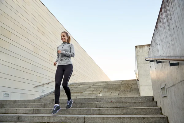 Mujer deportiva feliz corriendo abajo en la ciudad — Foto de Stock