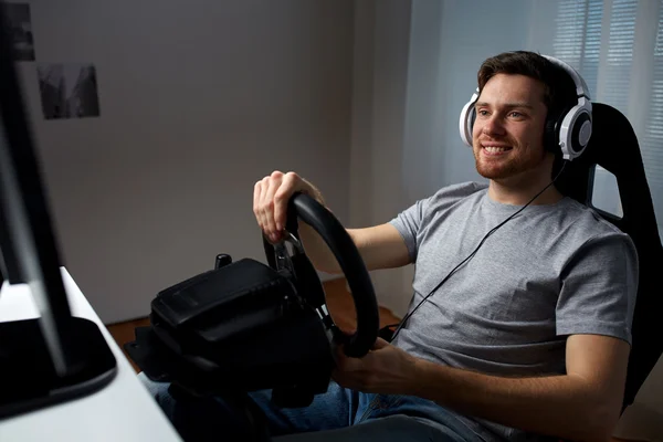 Man playing car racing video game at home — Stock Photo, Image