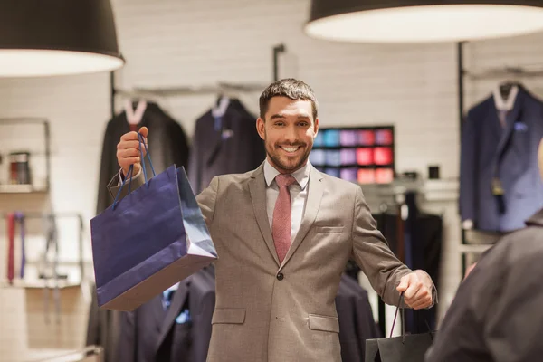 Щасливий чоловік з сумками в магазині одягу — стокове фото