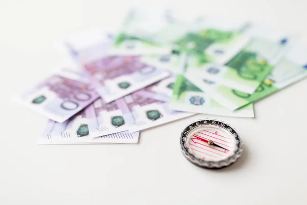 Close up of compass and euro money on table — Stock Photo, Image